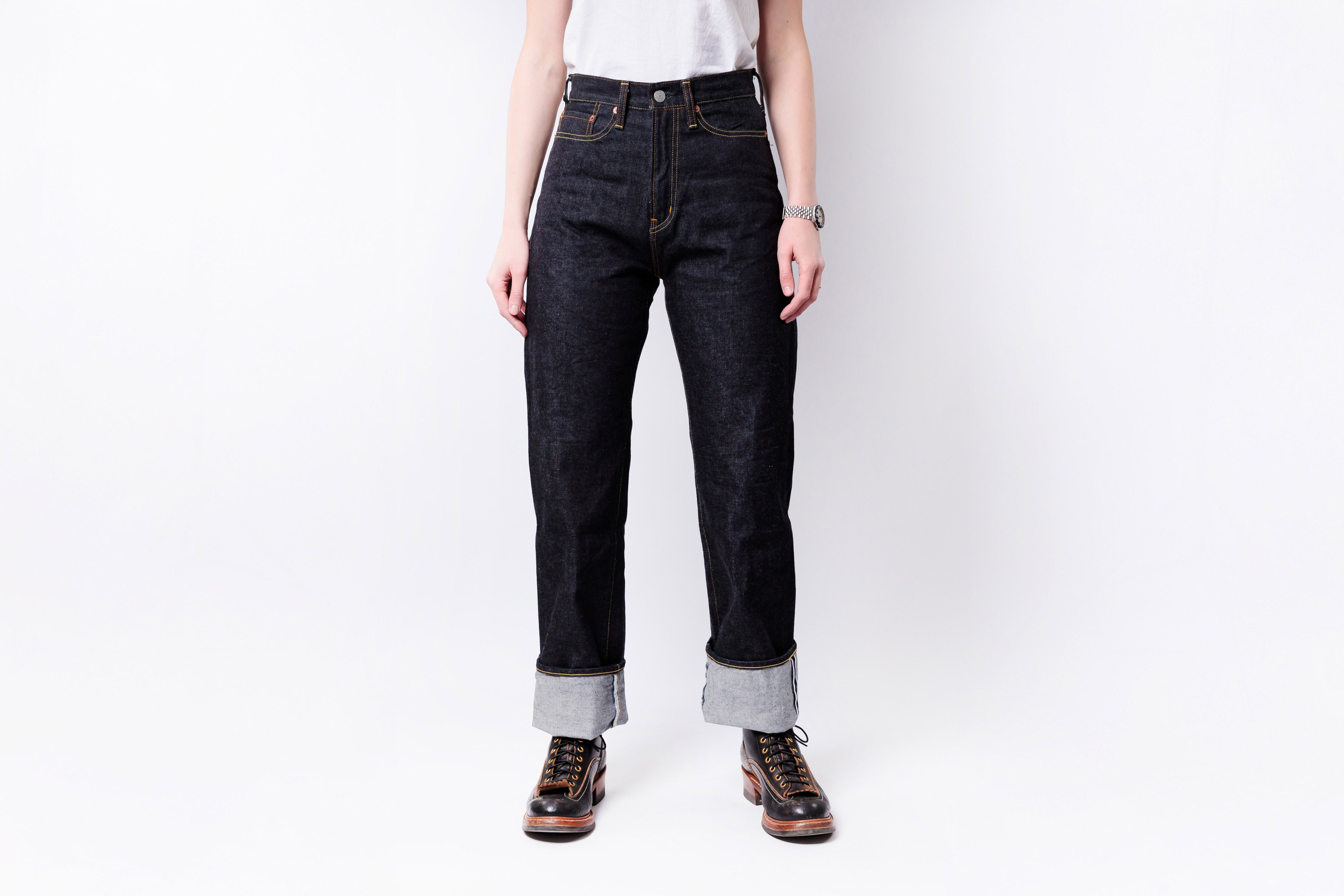 Person wearing dark blue jeans with a white background
