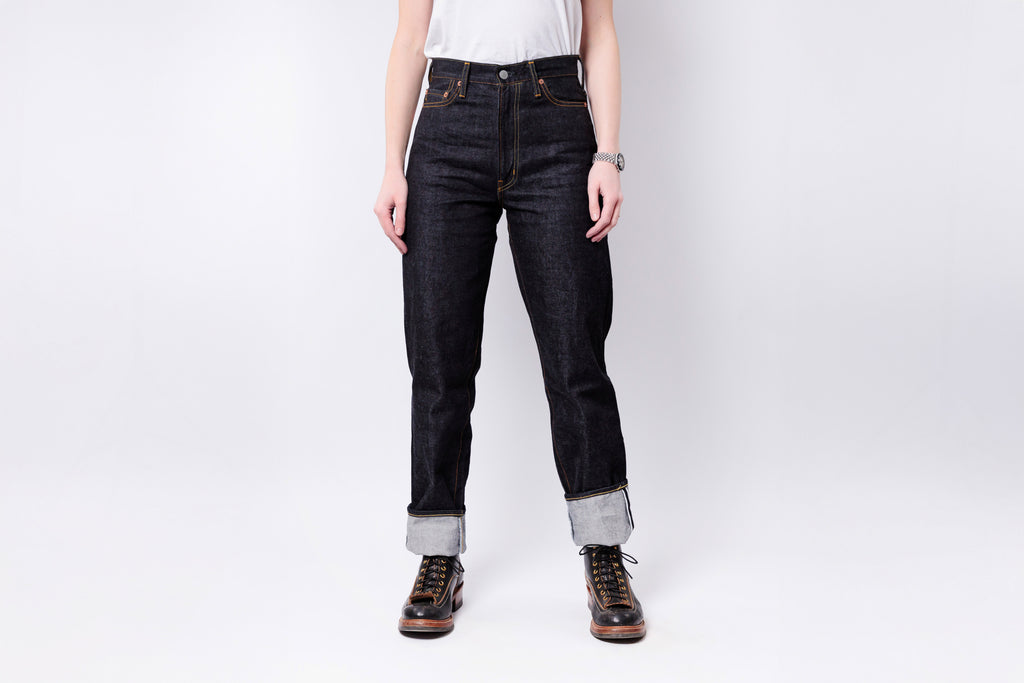 Person wearing dark jeans and boots on a white background