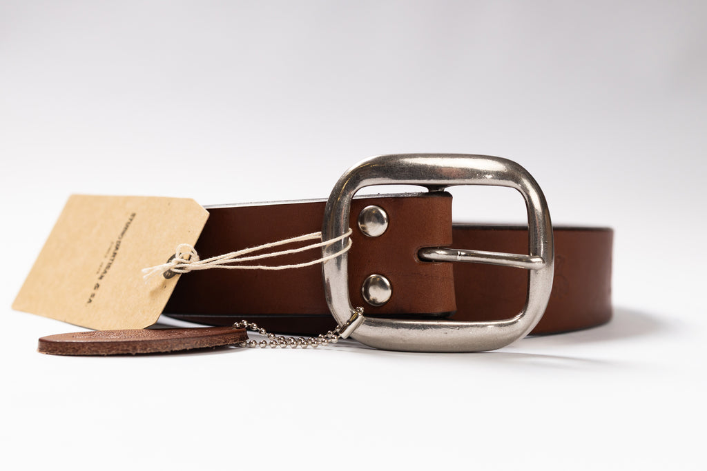 Brown leather belt with silver buckle on a white background