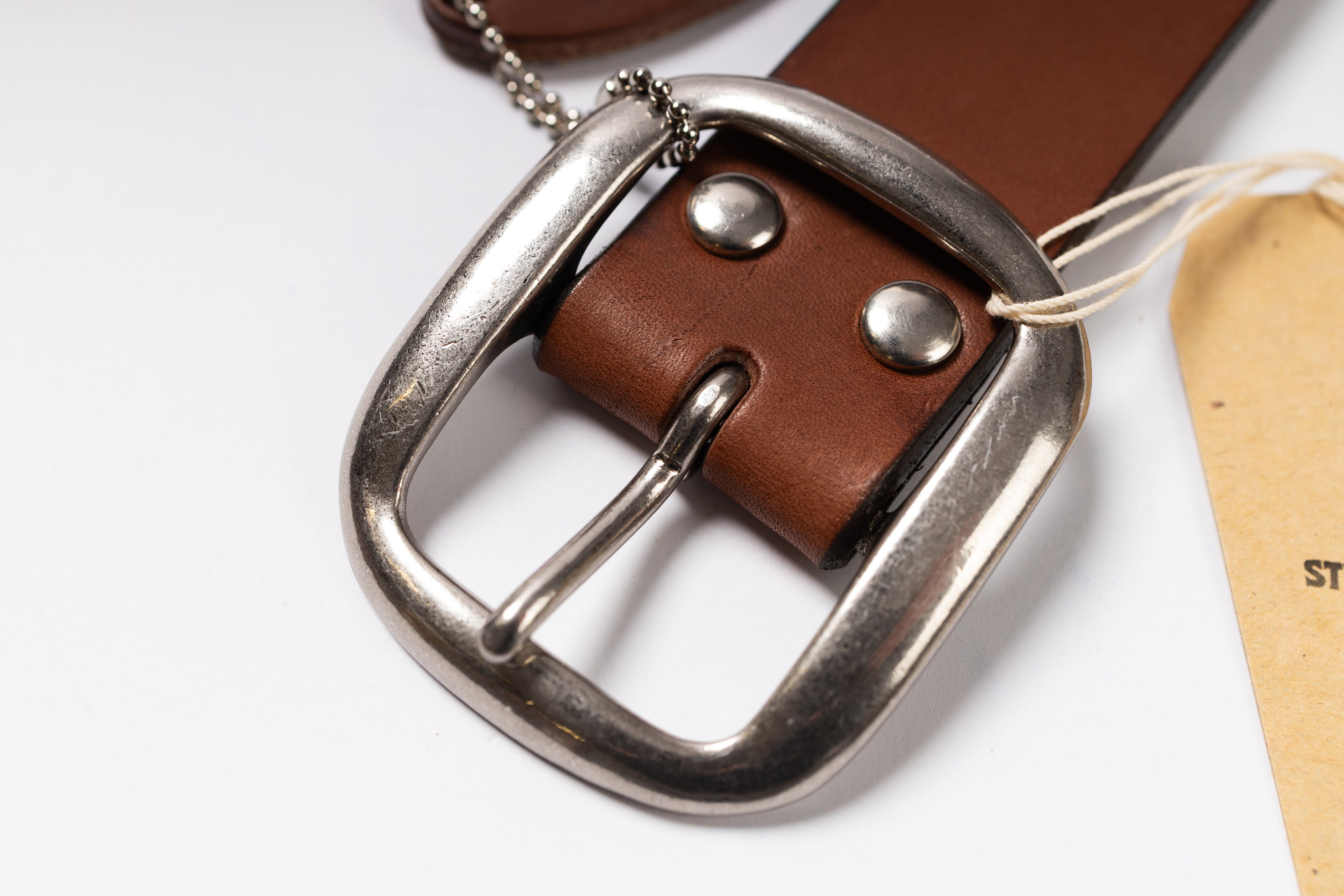 Brown leather belt with silver buckle on a white background