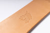 Close-up of a tan leather strap with an embossed logo on a light gray background