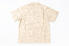 A short-sleeve camp collar shirt in beige with a light brown scenic toile-style print, shown flat against a white background.