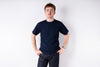 Man wearing a dark blue t-shirt and jeans against a white background