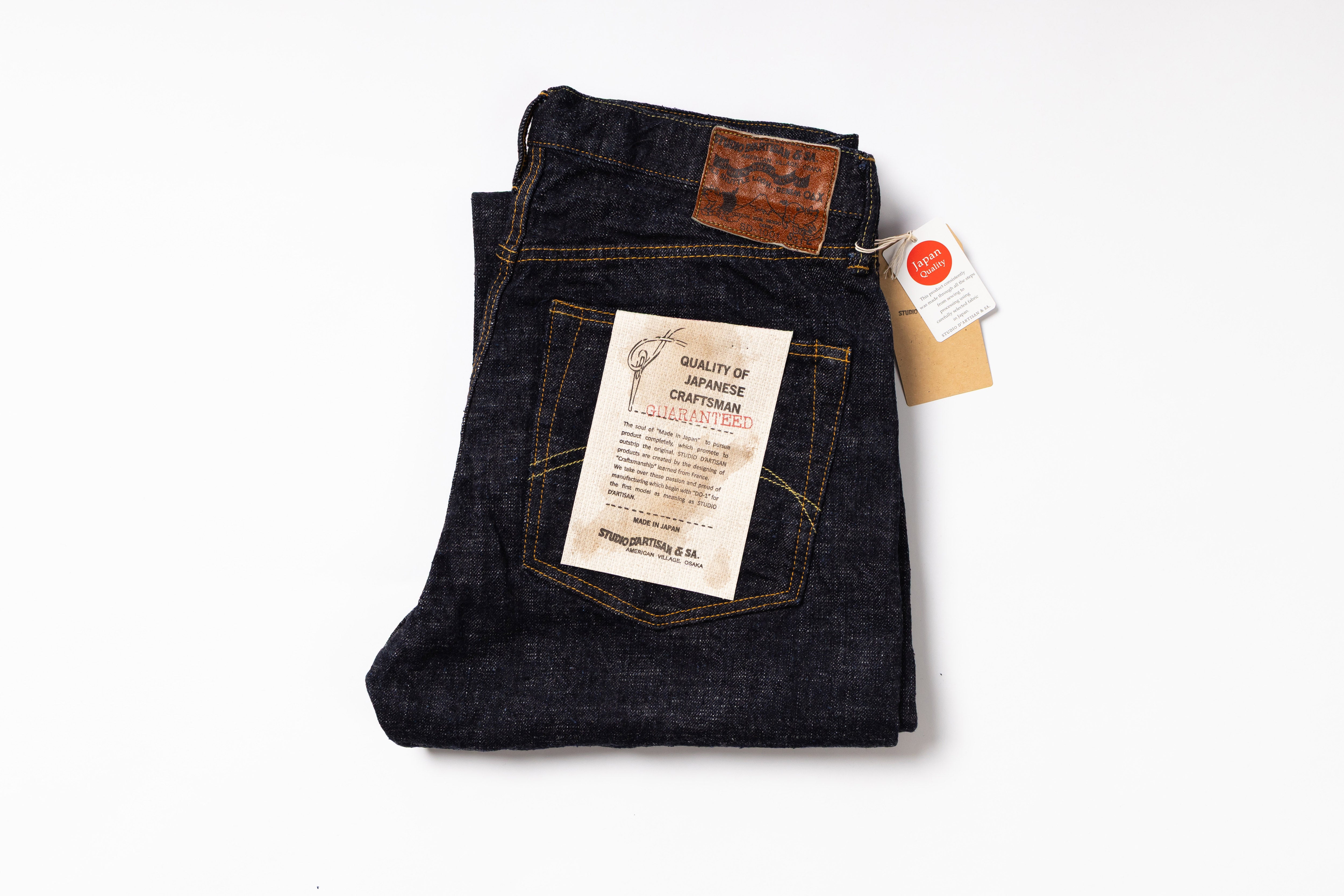 Folded pair of jeans with a tag on a white background
