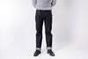 Person wearing dark jeans and a light gray sweater on a white background