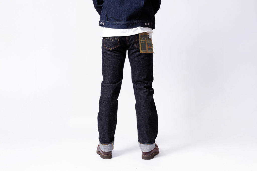 Person wearing dark blue jeans with a white background