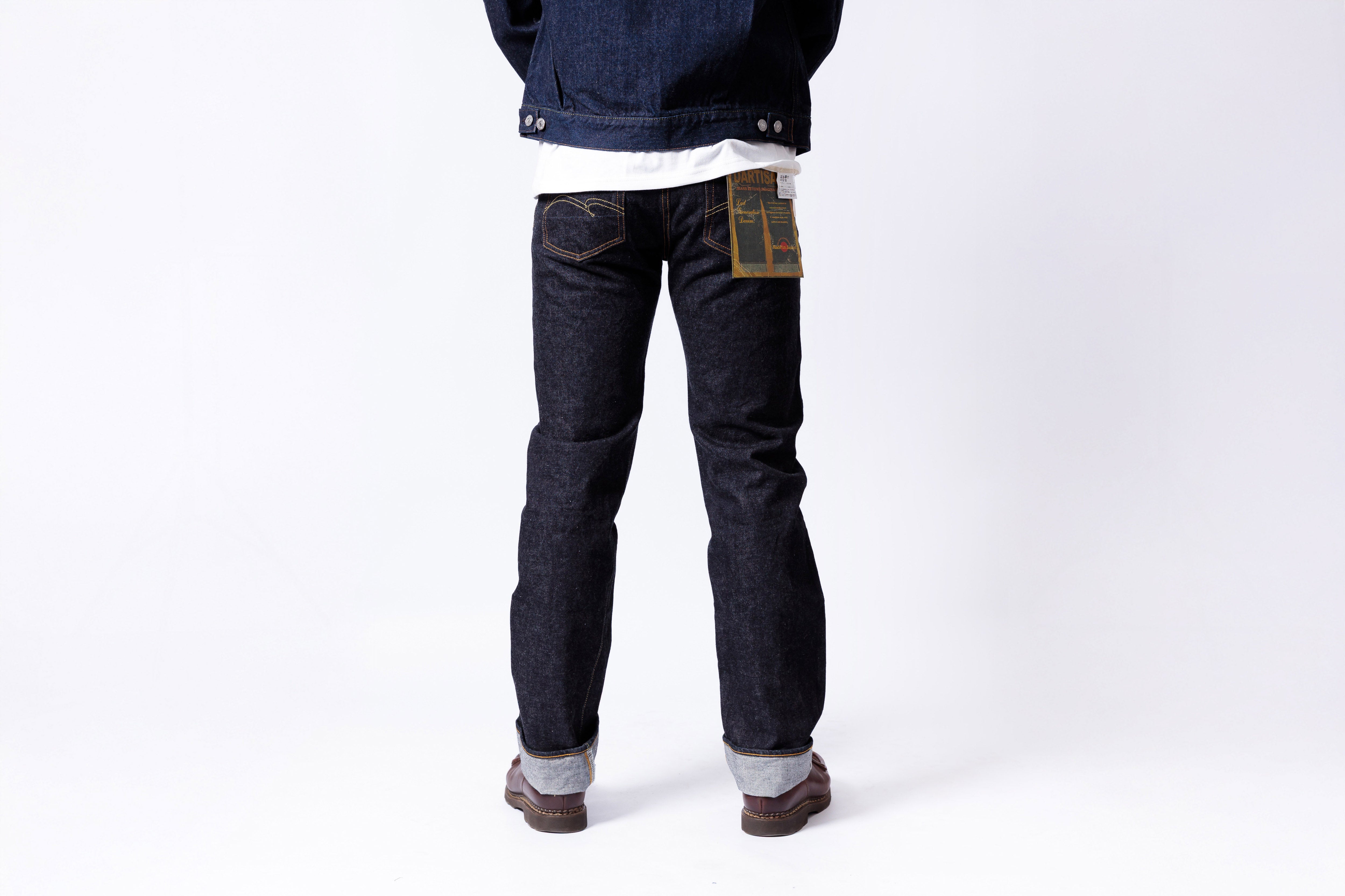 Person wearing dark blue jeans with a white background