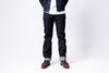 Person wearing dark jeans and a denim jacket on a white background