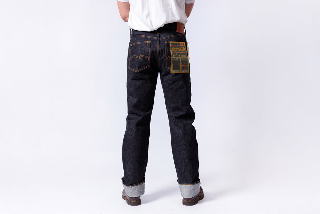 Person wearing dark blue jeans with a patch on a white background