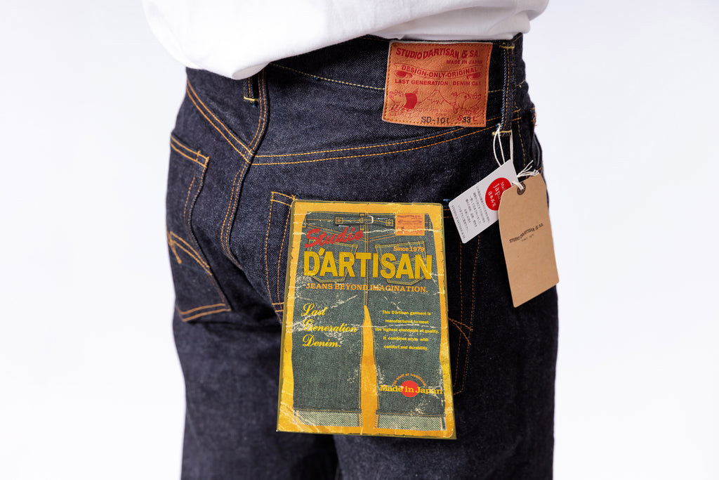 Pair of blue jeans with a visible brand label on a white background