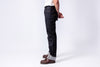 Person wearing dark blue jeans and brown shoes on a white background