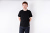 Person wearing a black t-shirt and jeans on a white background