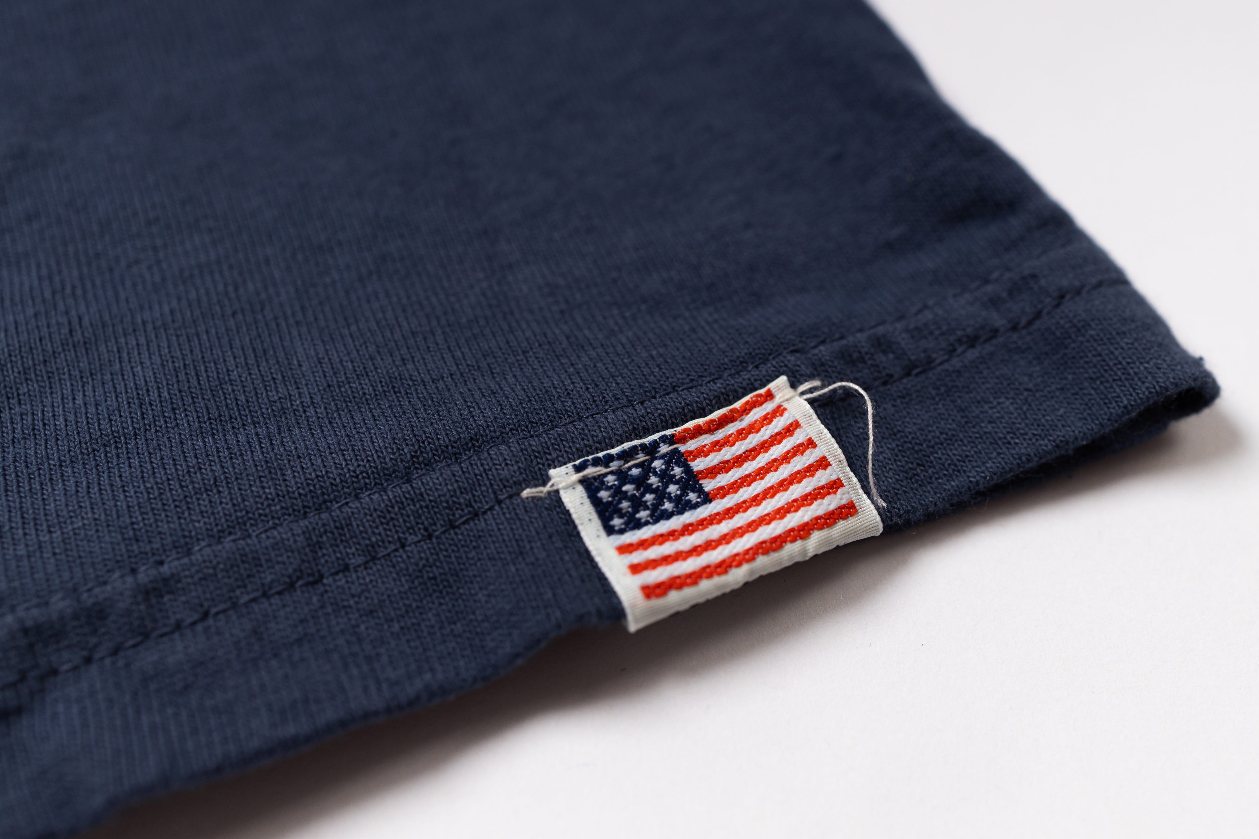 Navy blue fabric with an American flag label on a white background