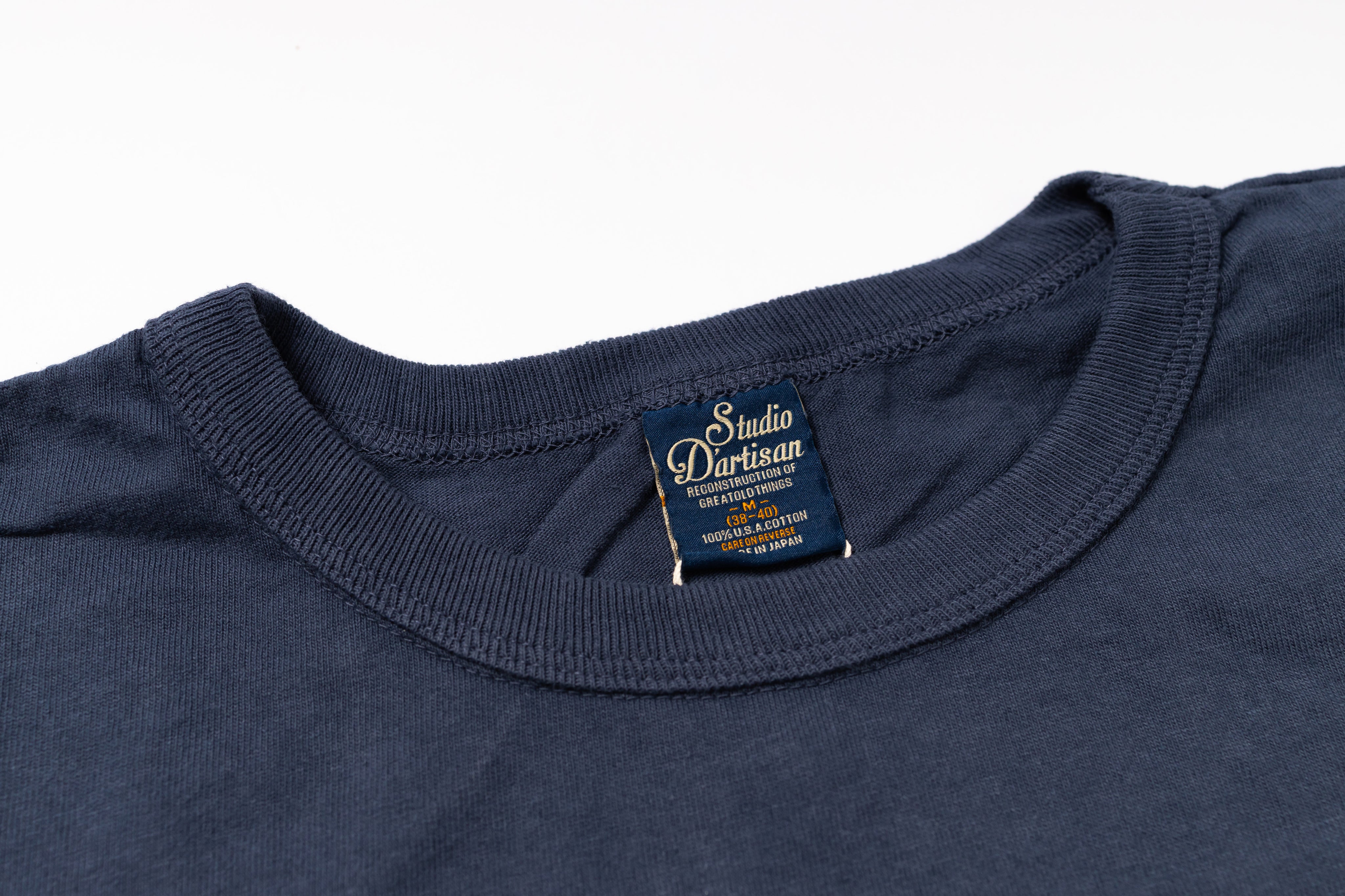 Navy blue t-shirt with a brand label on a white background