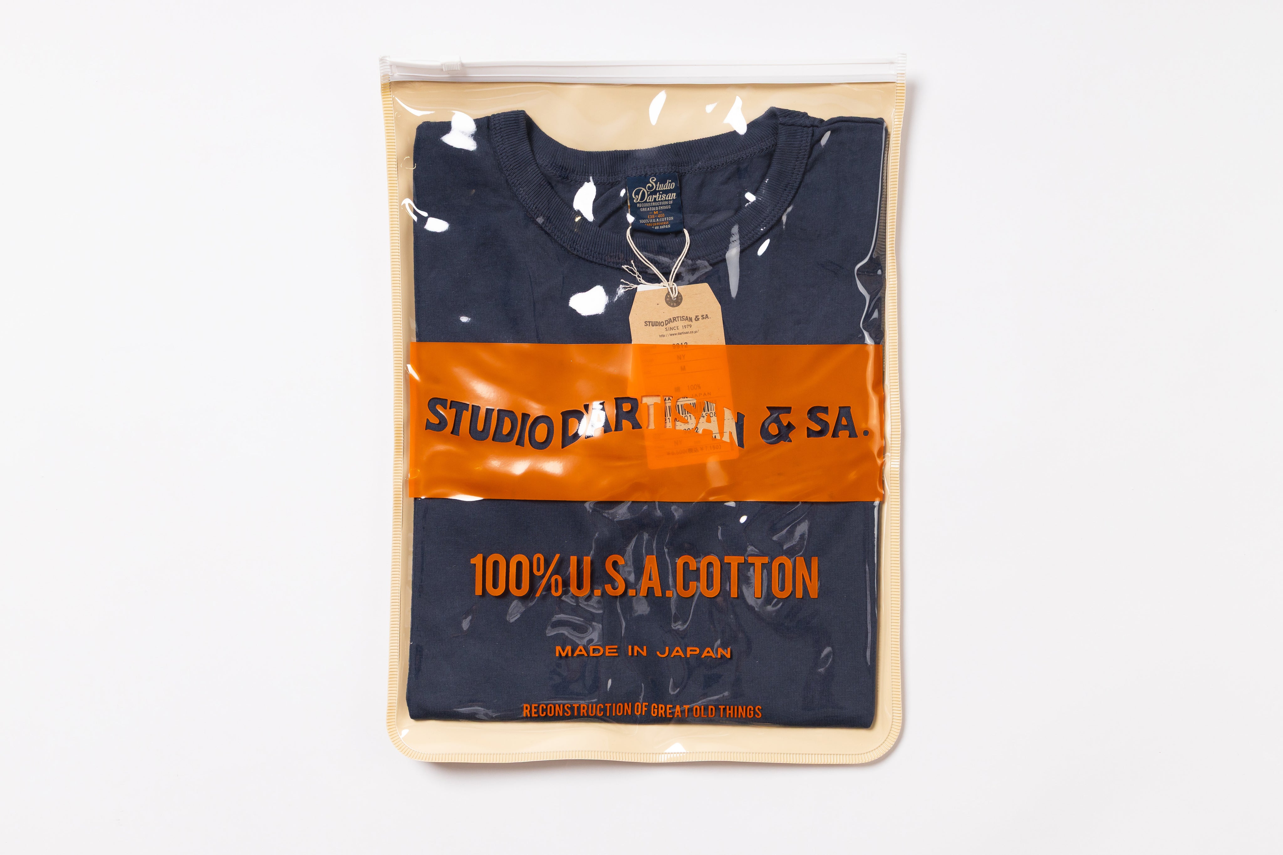 Packaged navy blue t-shirt with orange label on a white background