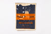 Packaged navy blue t-shirt with orange label on a white background