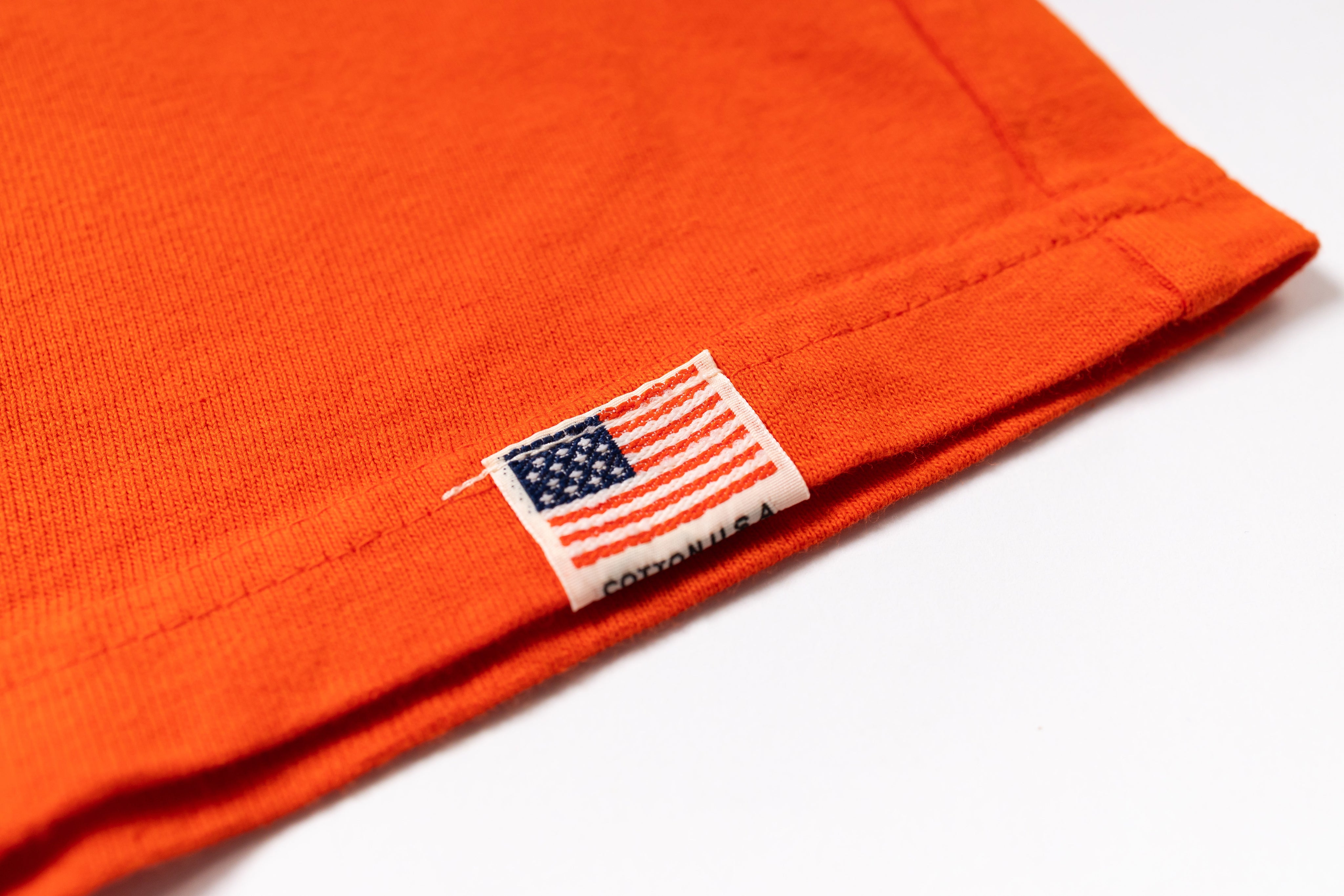 Close-up of an orange fabric with a U.S. flag label on a white background