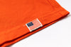 Close-up of an orange fabric with a U.S. flag label on a white background