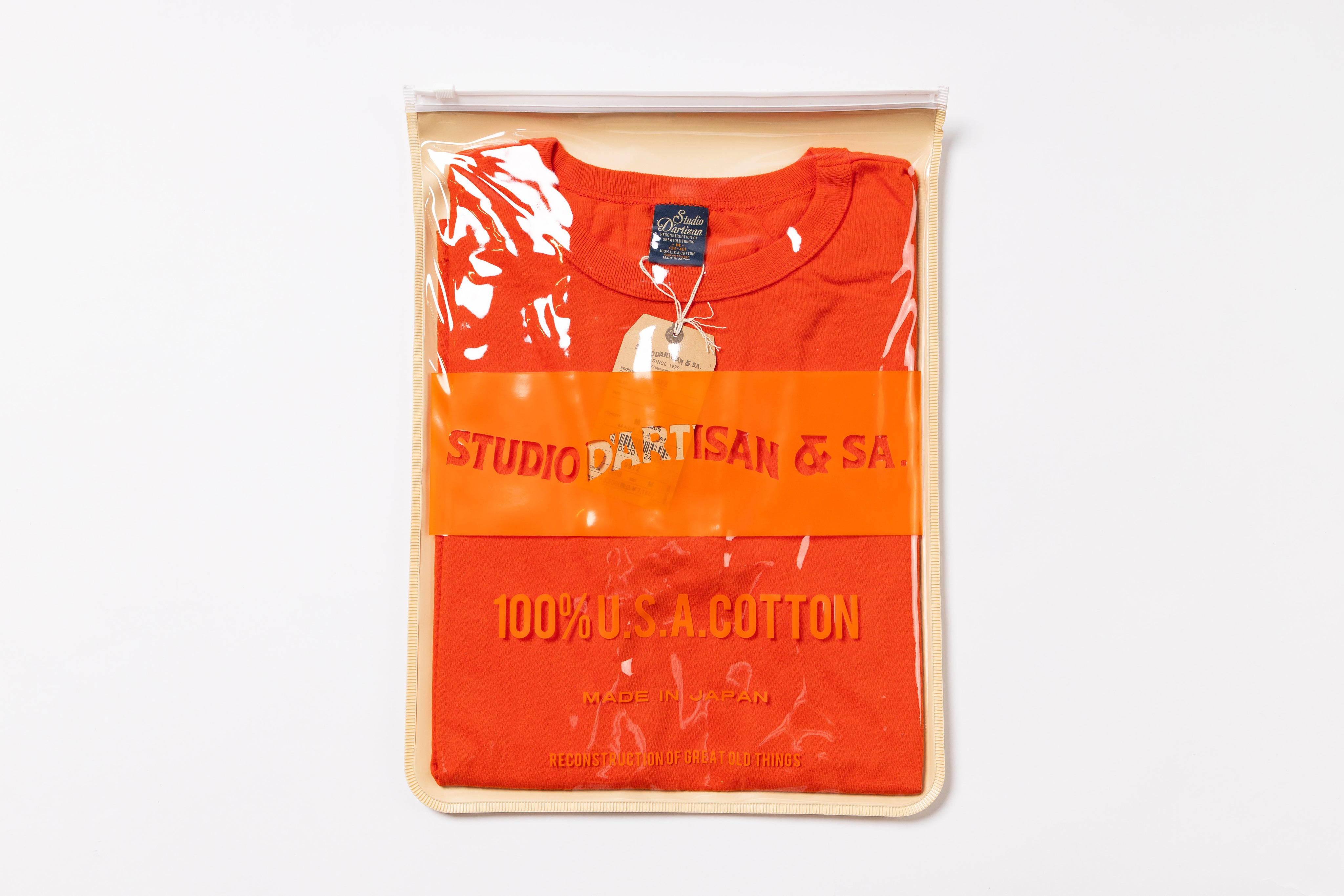 Orange t-shirt with text on packaging against a white background