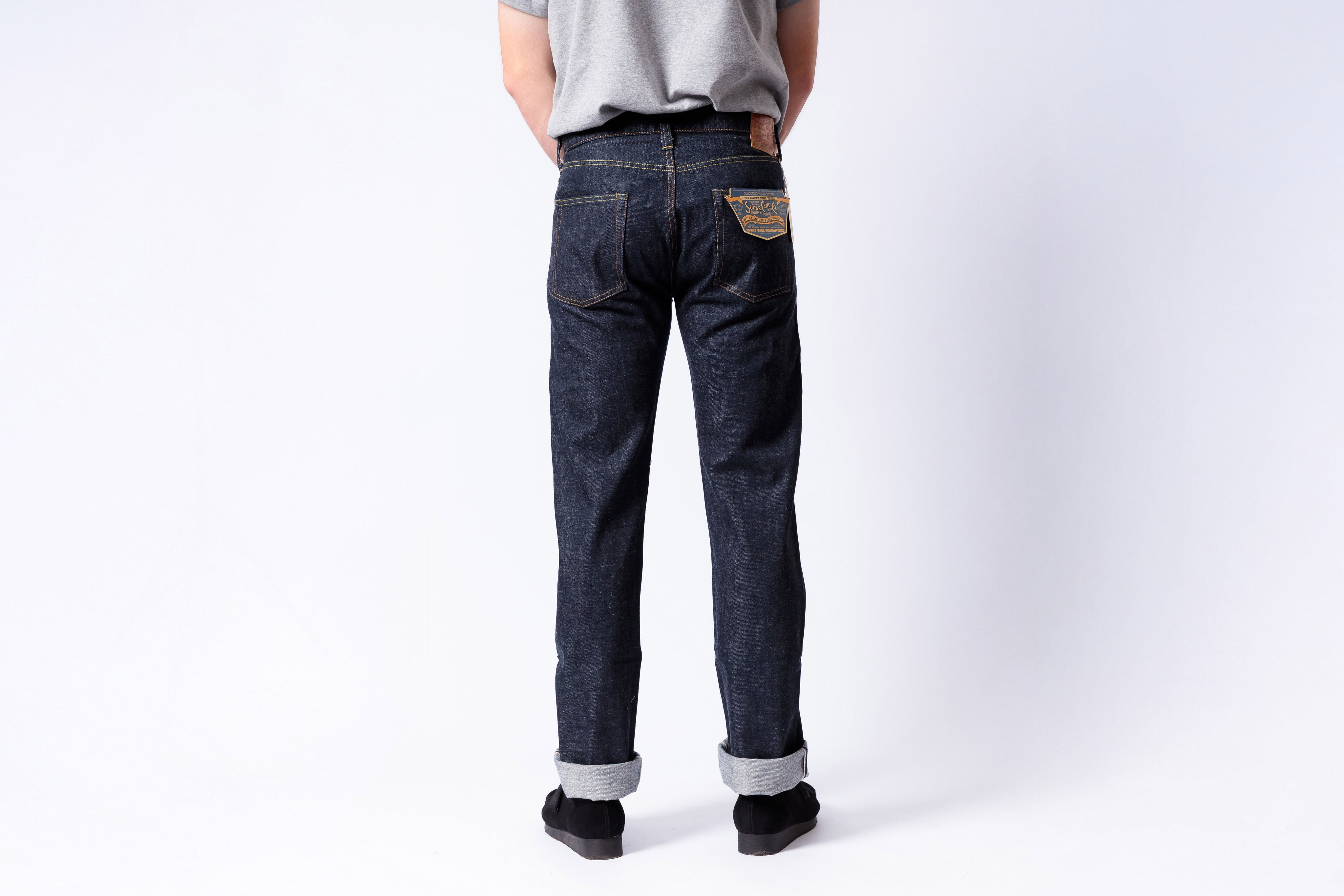 Person wearing dark blue jeans on a white background