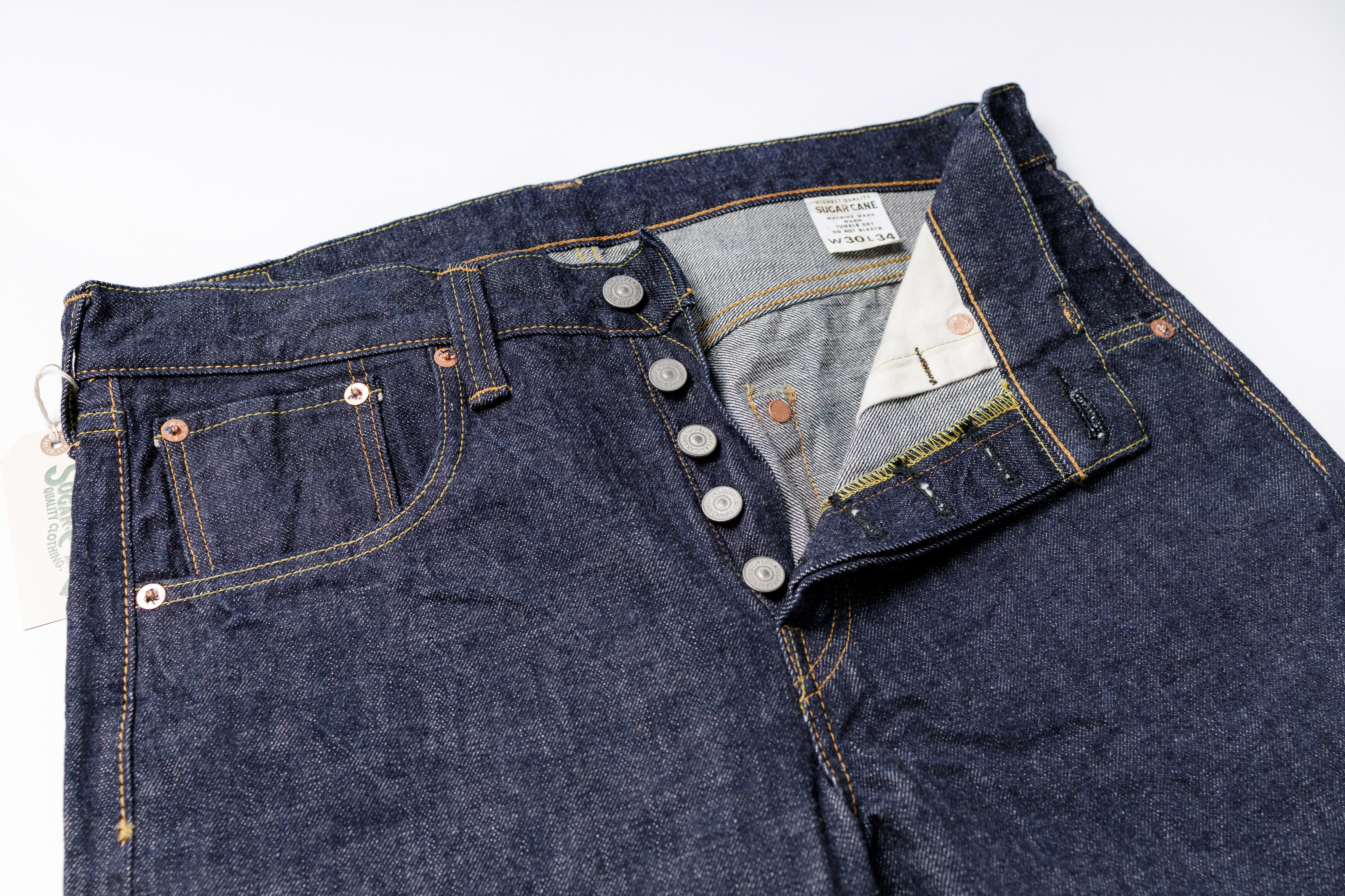 Close-up of a pair of blue jeans with a brand label on a white background