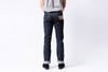 Person wearing dark blue jeans on a white background