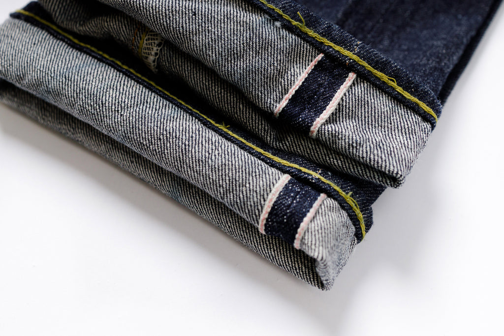 Folded denim jeans with a white background