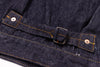 Close-up of a dark blue denim fabric with a belt and button details.