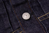 Close-up of a button on dark blue denim fabric with 'Levi's' branding.