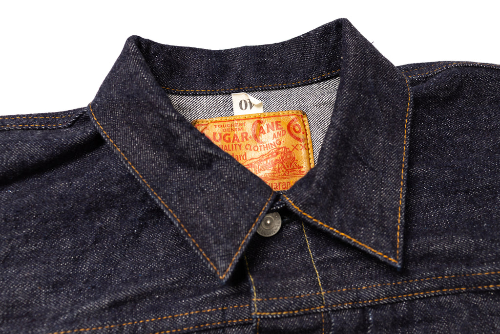 Close-up of a denim jacket collar with a brand label on a white background