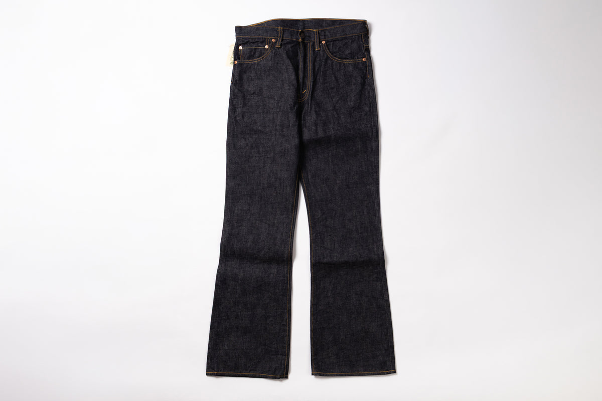 A pair of dark indigo denim jeans with a straight-to-flare leg, laid flat against a clean white background.