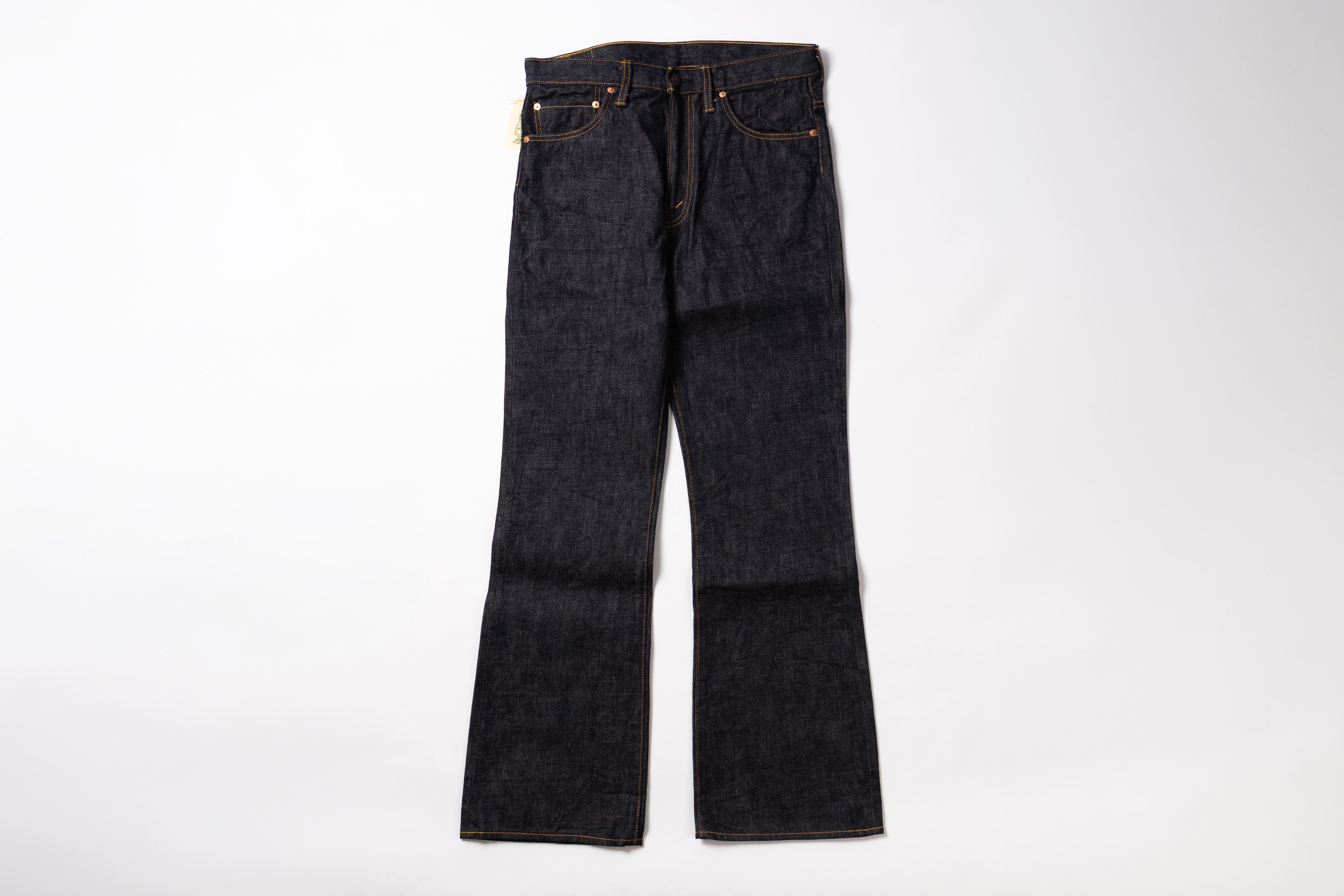 A pair of dark indigo denim jeans with a straight-to-flare leg, laid flat against a clean white background.
