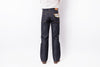 Rear view of a person wearing dark indigo denim jeans with a white shirt, shown against a plain white studio background.