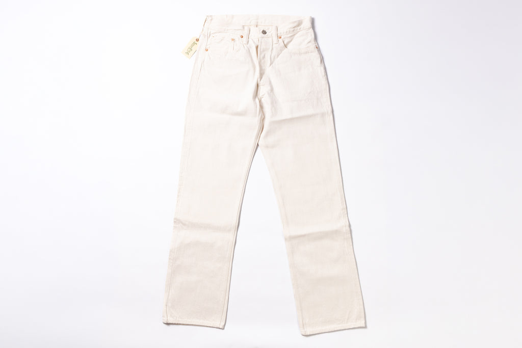 A pair of off-white or cream-colored denim jeans laid flat against a solid white background.