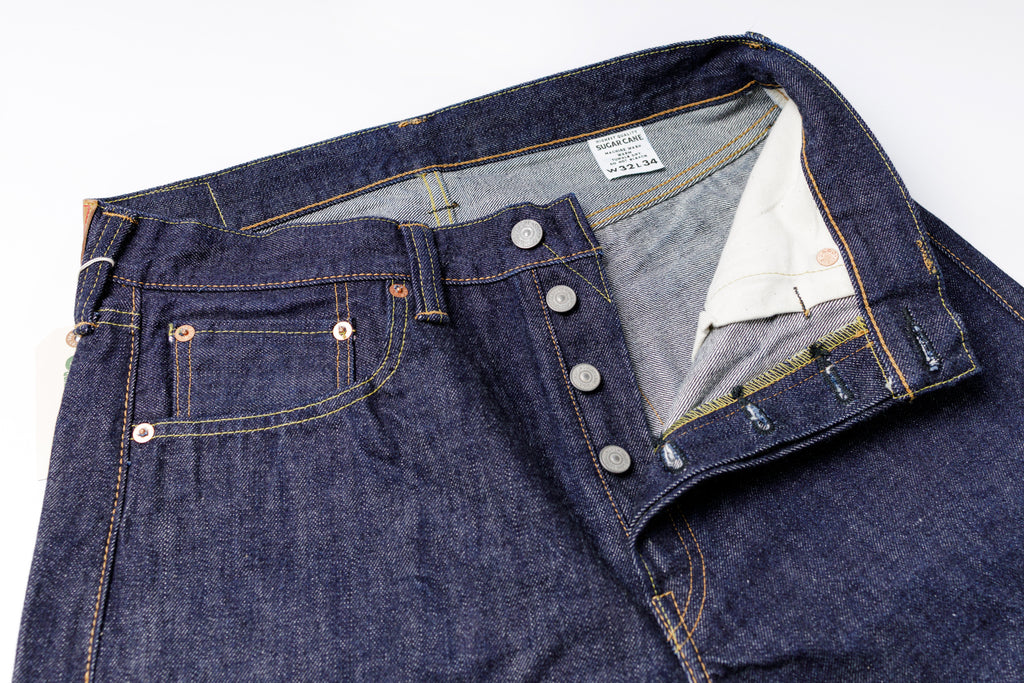 Close-up of a pair of blue jeans with a focus on the button and stitching details.