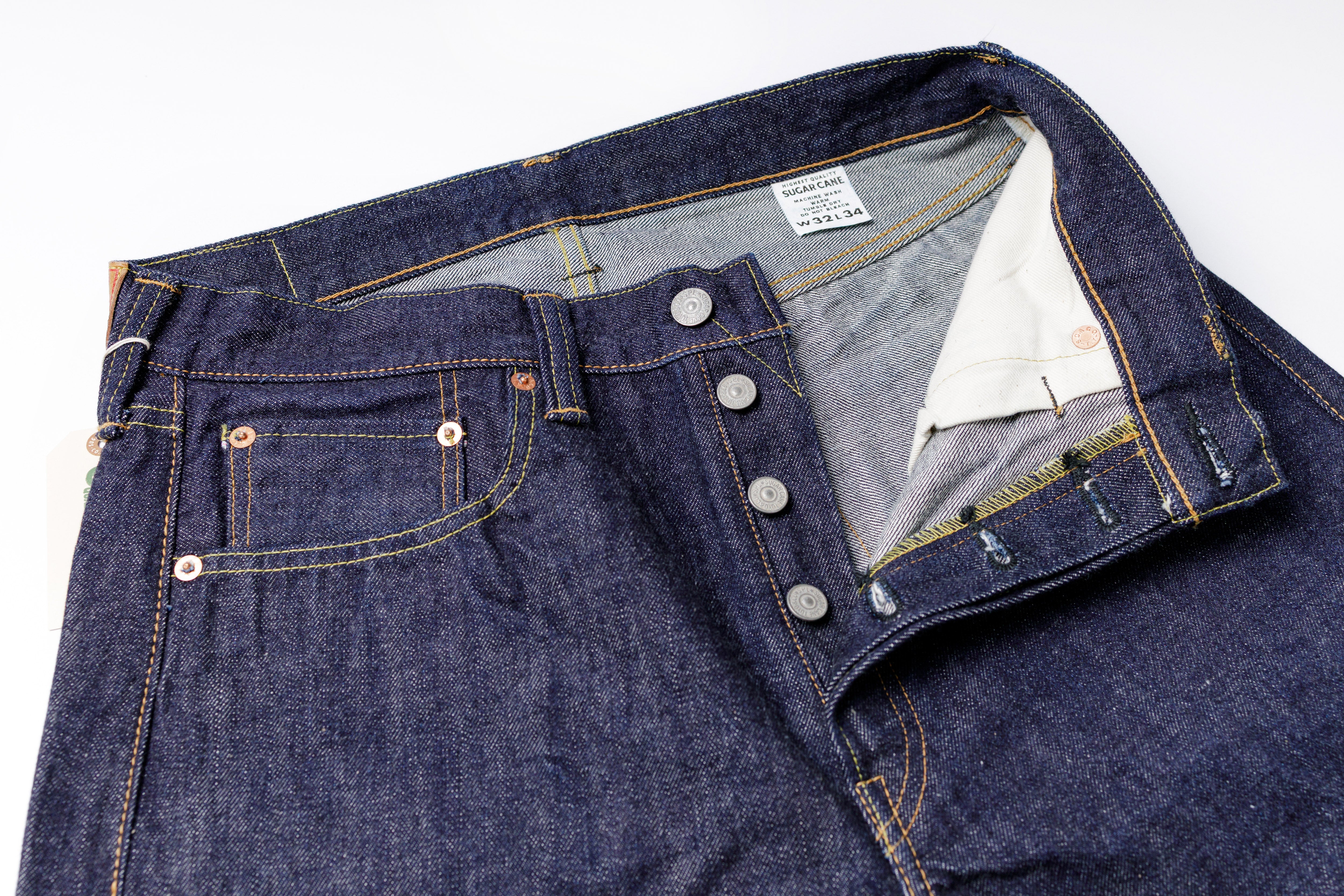 Close-up of a pair of blue jeans with a focus on the button and stitching details.