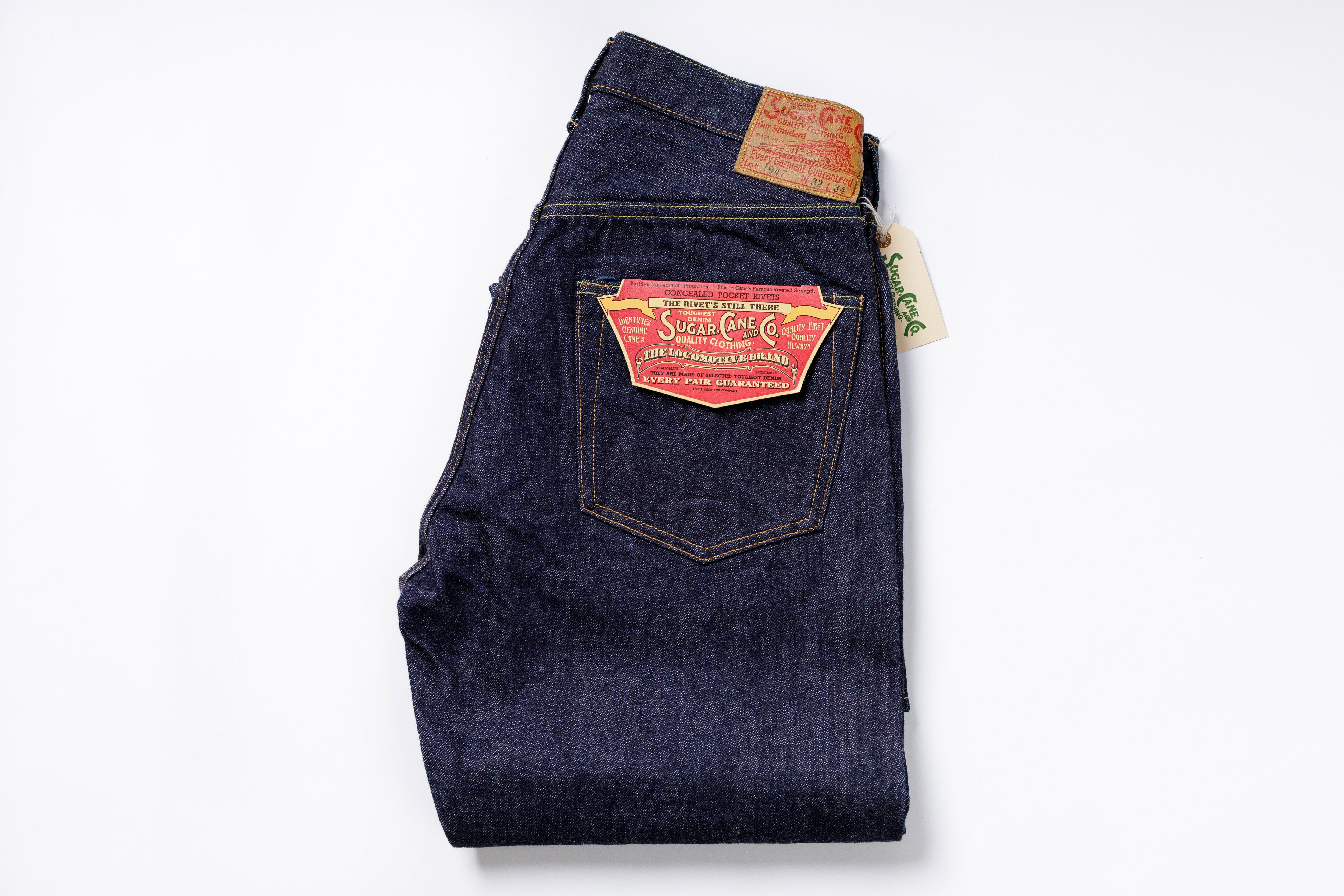 Folded pair of blue jeans with a brand label on a white background