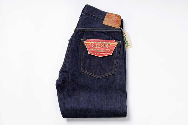 Folded pair of blue jeans with a brand label on a white background