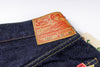 Close-up of a denim garment with a 'Sugar Cane' label on a white background