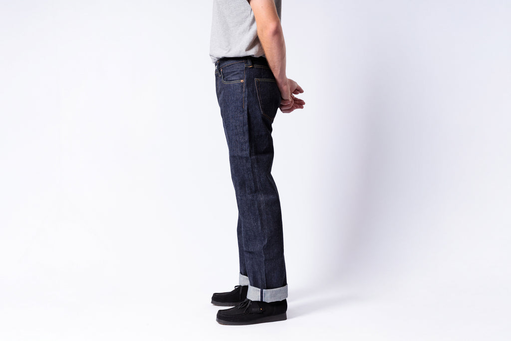 Person wearing dark blue jeans on a white background