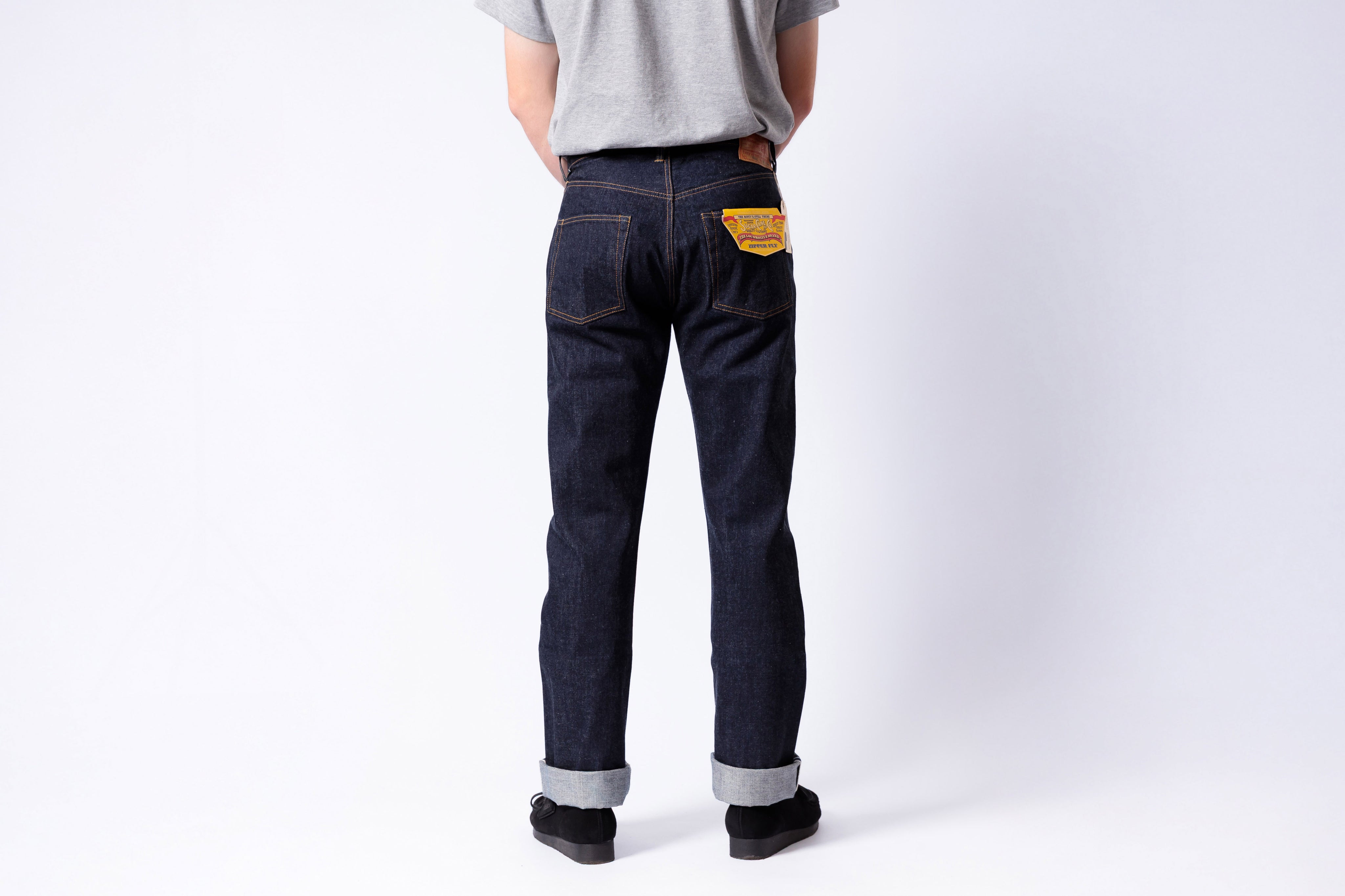 Person wearing dark blue jeans with a white background
