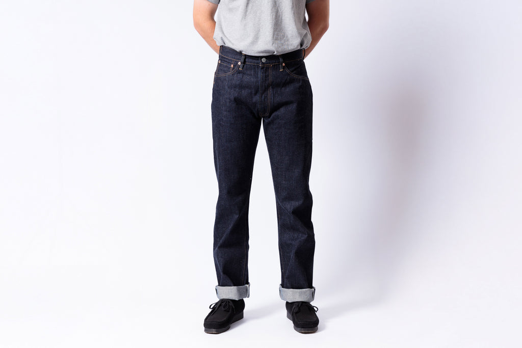 Person wearing dark blue jeans on a white background