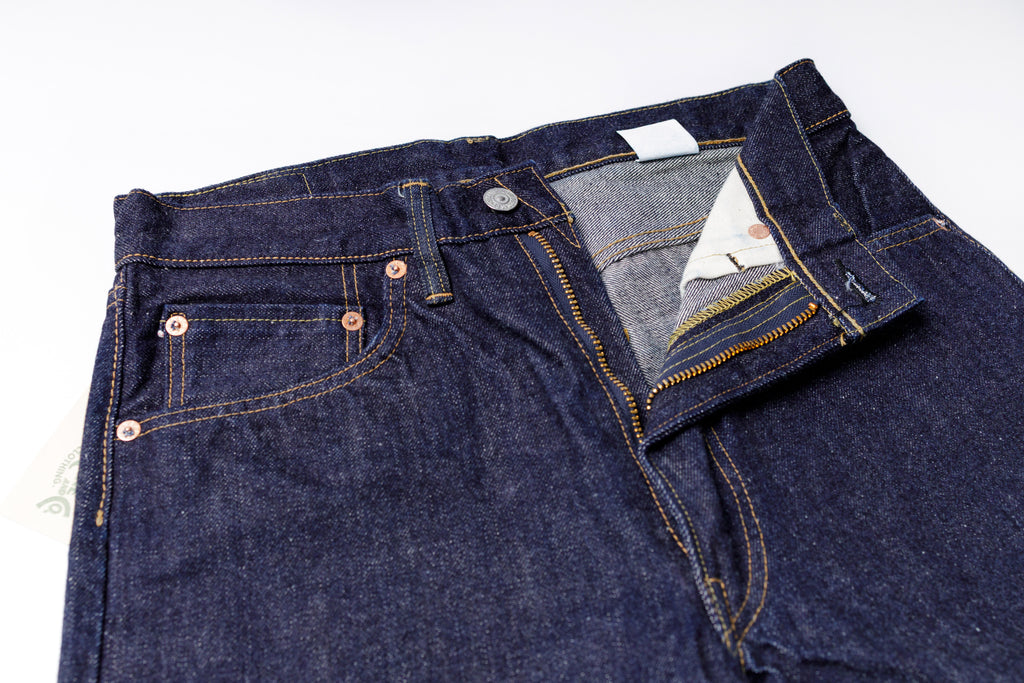Pair of blue jeans with a visible brand label on a white background