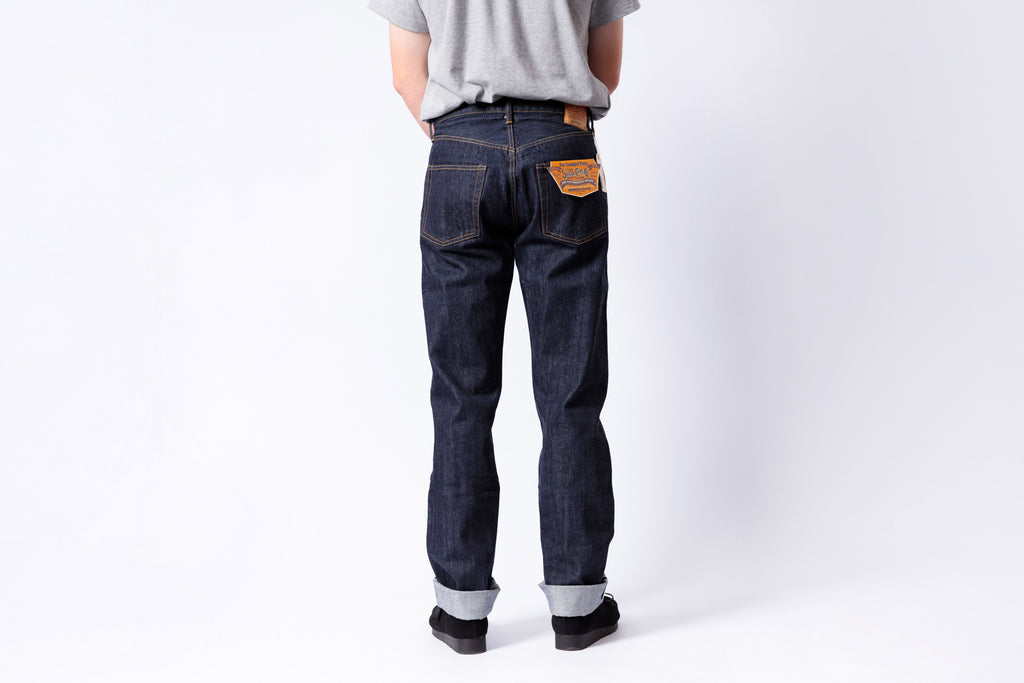 Person wearing dark blue jeans on a white background