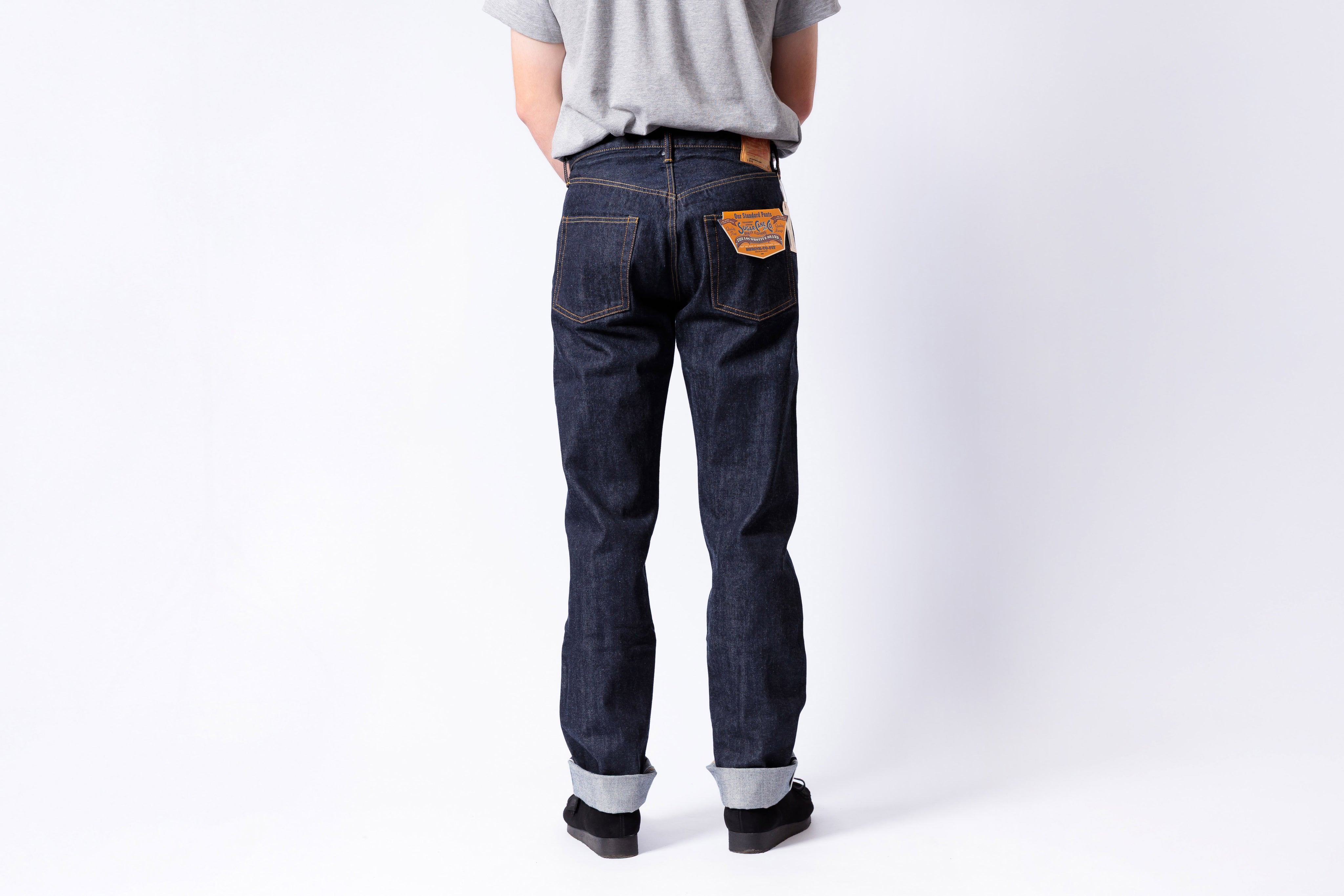 Person wearing dark blue jeans on a white background