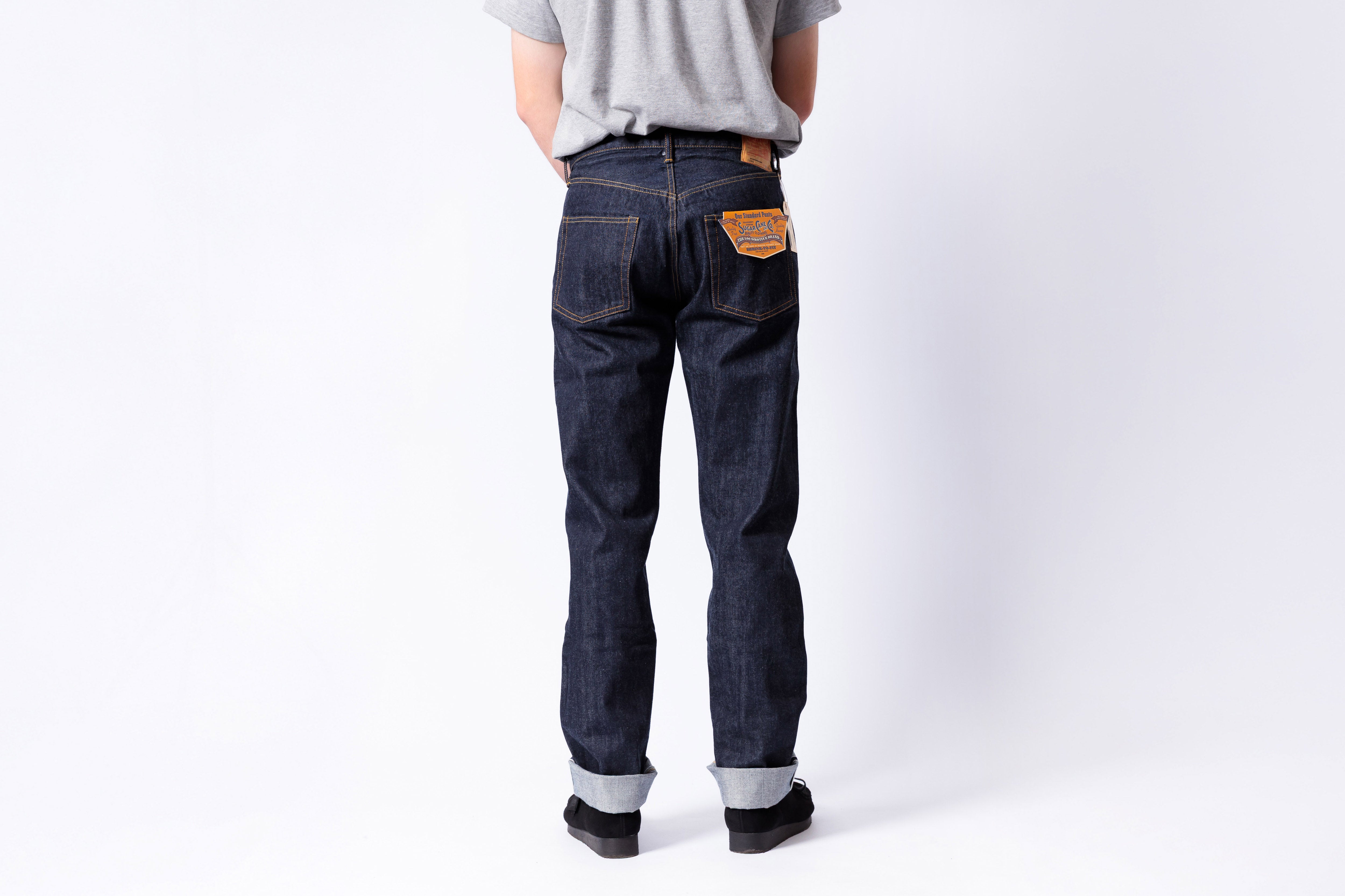 Person wearing dark blue jeans on a white background