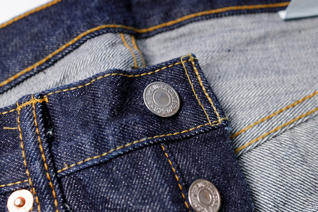 Close-up of a button on a pair of blue jeans