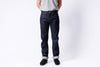 Person wearing dark blue jeans and a light gray shirt on a white background