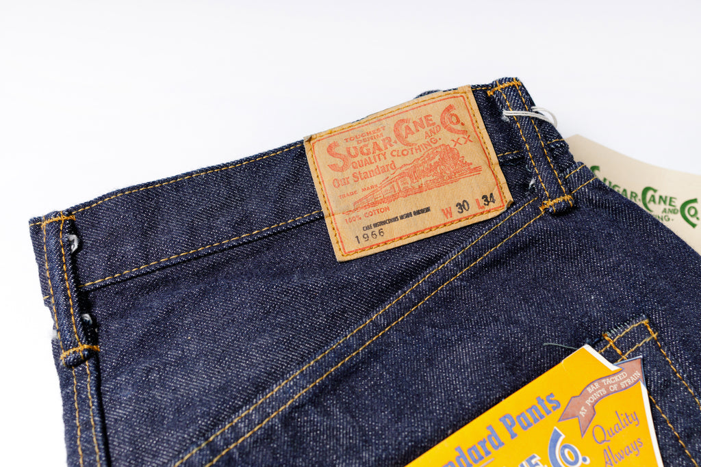 Close-up of a pair of blue jeans with a brand label on a white background