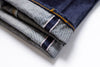 Stack of folded denim jeans on a white background